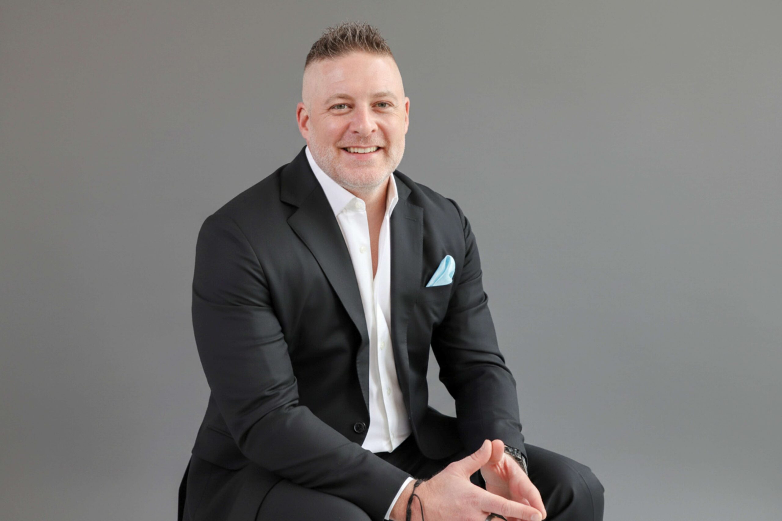 Smiling businessman in black suit with pocket square